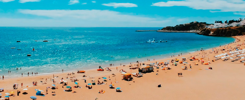 pessoas numa praia de albufeira no Algarve a aproveitar um dia ensolado