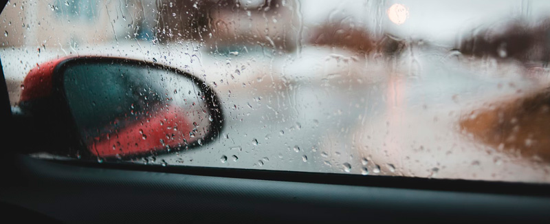 visão de dentro do carro do vidro com gotas de água devido à chuva num dia de inverno