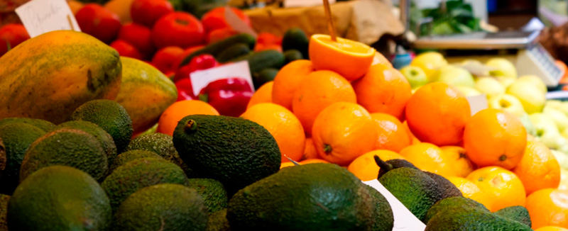 Green and orange fruits on display at a local market in Madeira, showcasing regional gastronomy and freshness.