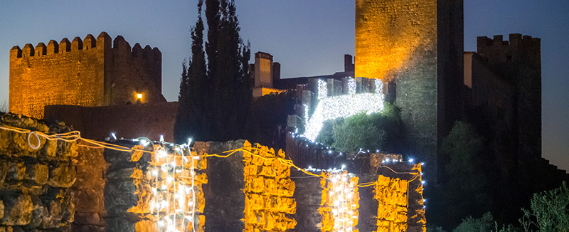 castelo de óbidos decorado com luzes para o mercado de natal num dia ao entardecer
