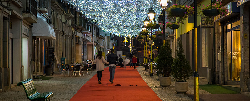 casal a passear numa rua turística em Águeda com decoração de natal