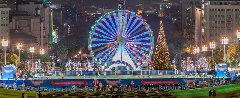 vista de roda gigante e arvore de natal iluminadas no mercado Wonderland em lisboa
