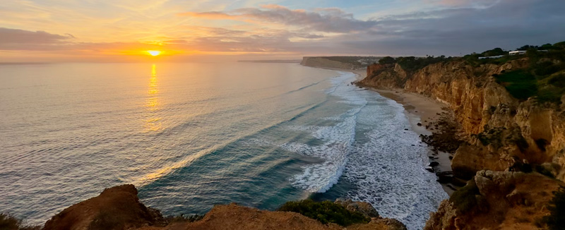 Sunset over the ocean in Faro, perfect for road trips in southern Portugal with a rental car and unique experiences with Hertz