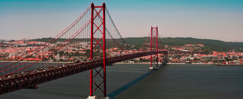 Ponte 25 de Abril em Lisboa, atravessando o rio Tejo ao entardecer