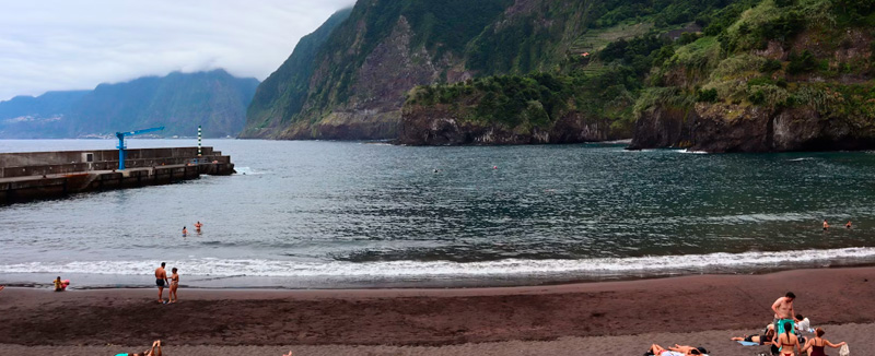 pessoas num dia de verão numa praia de areia preta na madeira