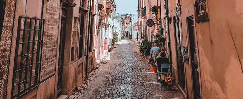rua estreita de paralelepípedos em Tomar sob o ceu azul durante o dia